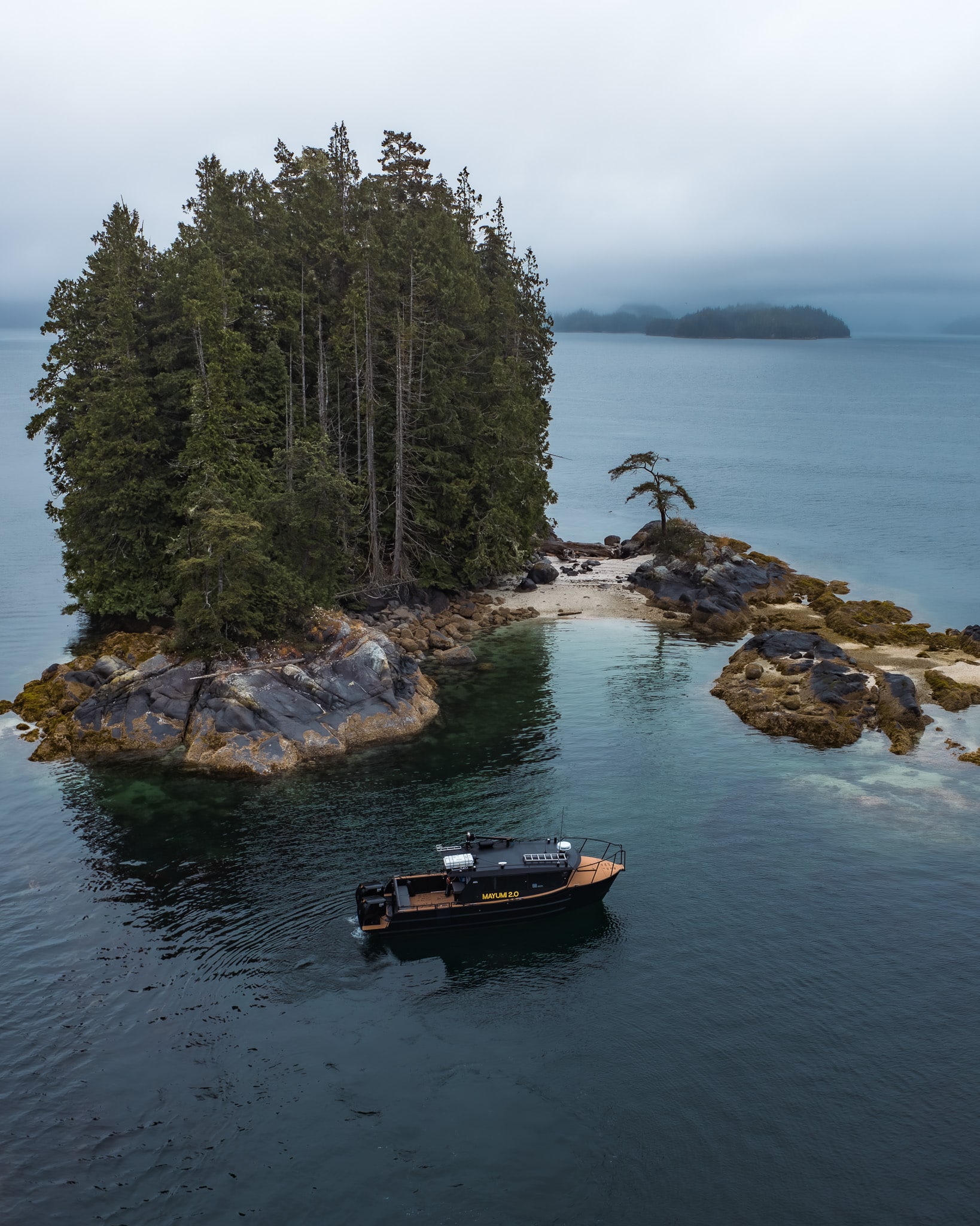Sea Wolf Adventures boat near rocky shoreline at low tide in Broughton Archipelago during Canadian wildlife holiday