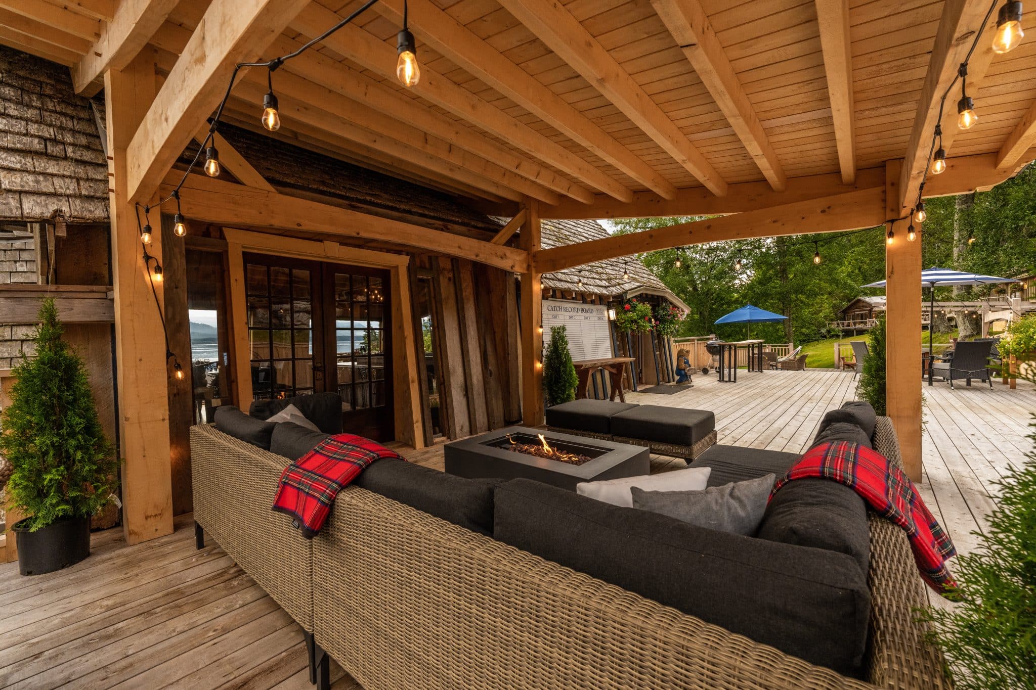 Sea Wolf Lodge deck with fire pit, string lights and Catch Record Board for evening gatherings