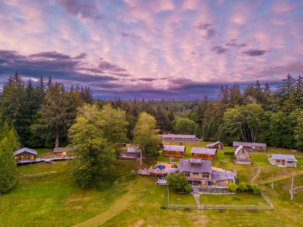 Wilderness lodge compound at sunset, showing respectful integration with Great Bear Rainforest landscape